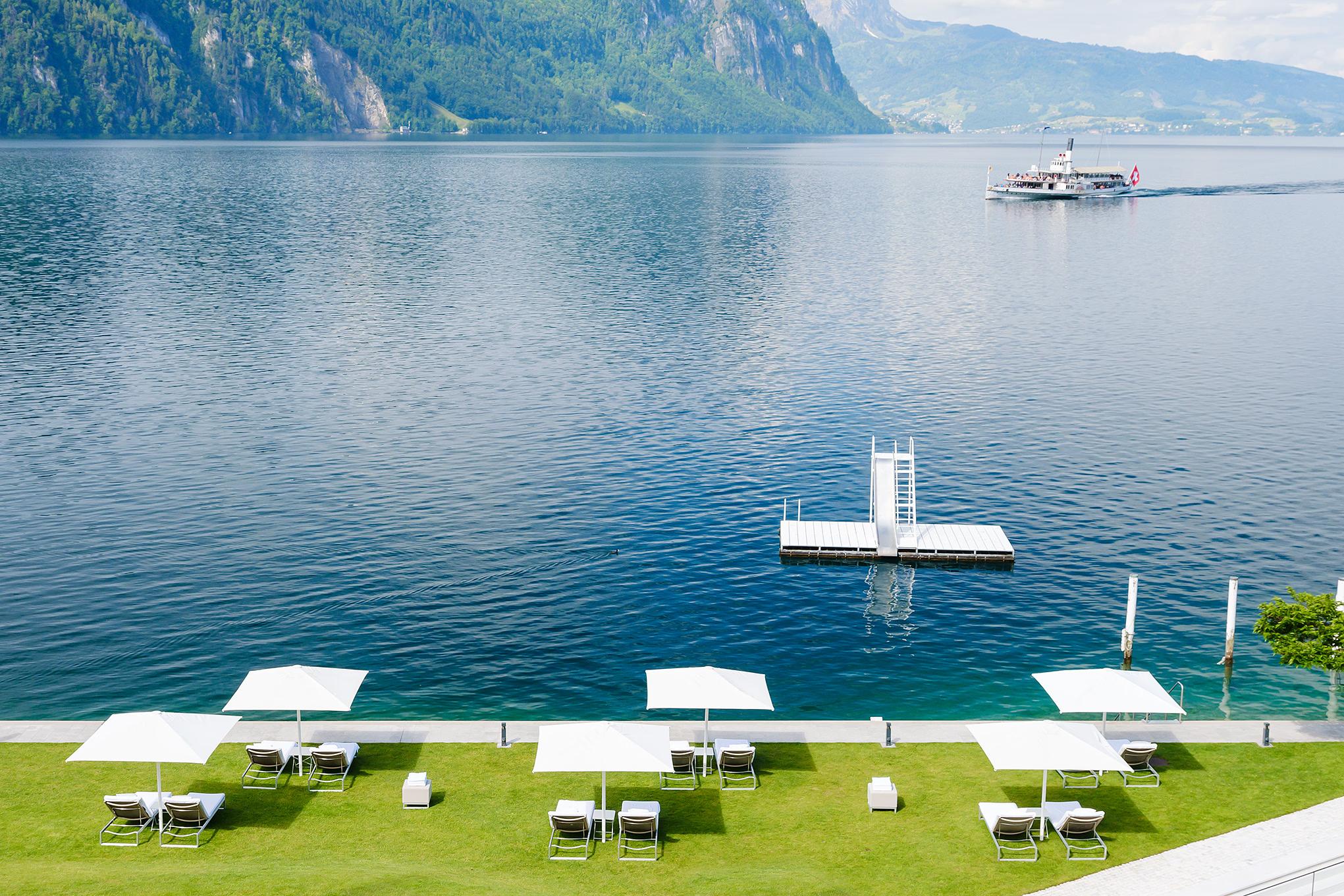 Waterfront promenade with floating dock and lawn seating overlooking the lake