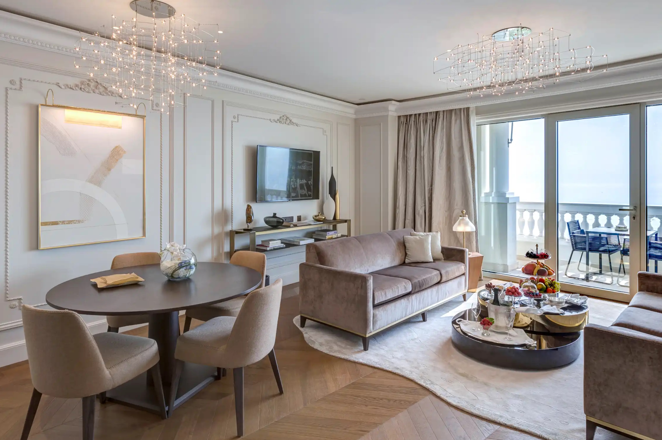 Suite living area in soft neutrals with round dining table and sea view