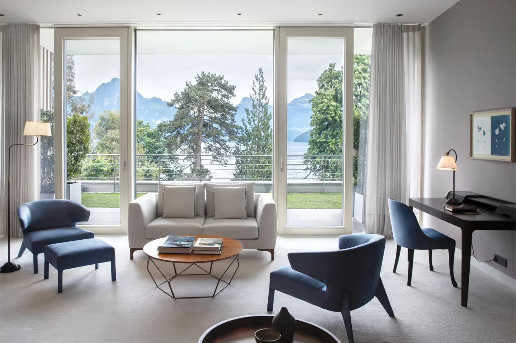 Modern living room with floor-to-ceiling windows, Alpine mountain views, and contemporary furnishings