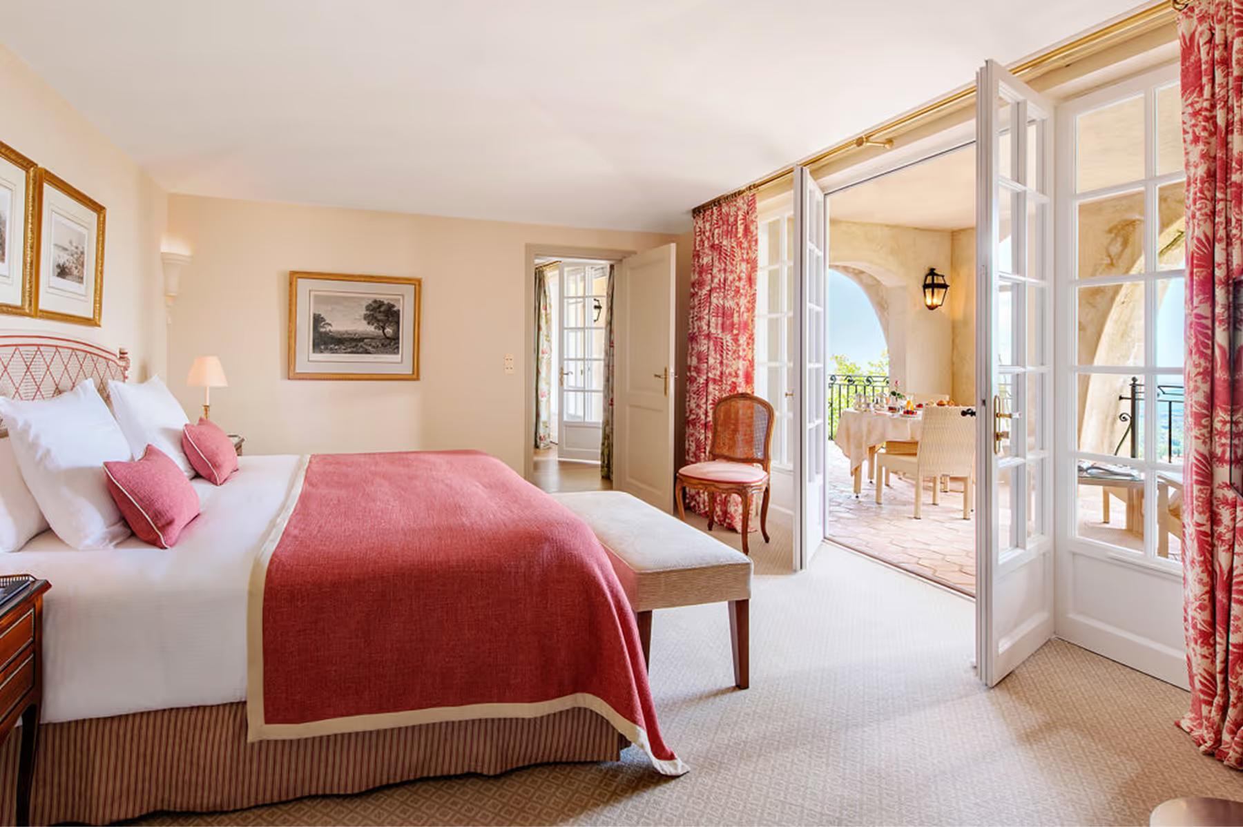 Château Saint Martin & Spa: guest bedroom with burgundy accents, sitting area, and arched windows