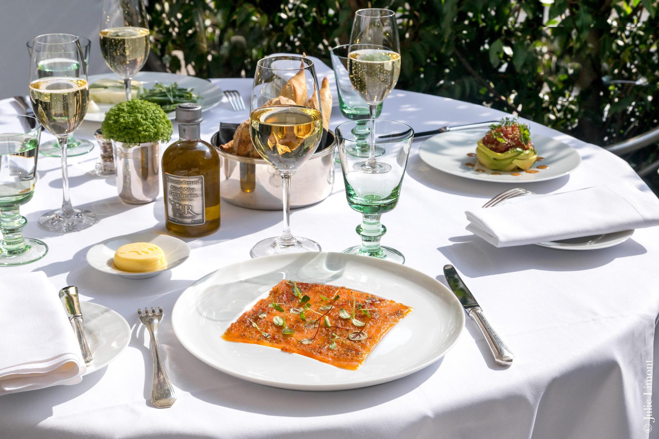 La Réserve Paris: an outdoor terrace table with white linens and Parisian monuments in the distance