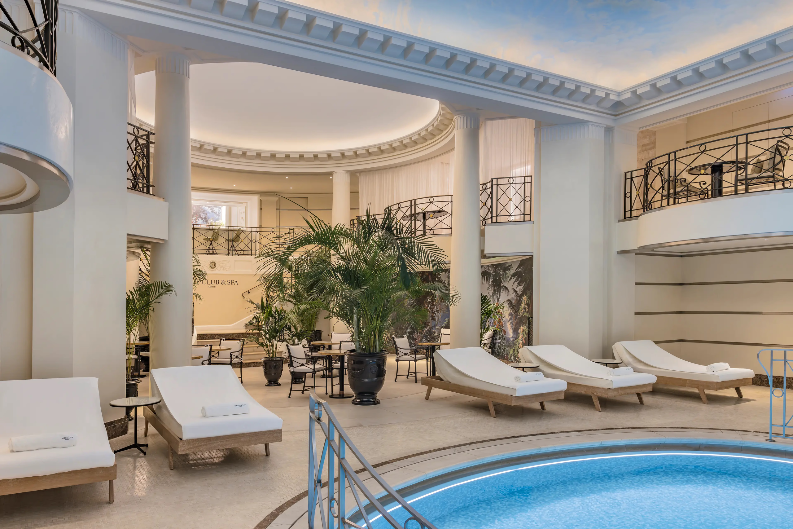 Ritz Paris: the spa lounge with indoor pool, arched alcoves, white loungers, and soft natural lighting