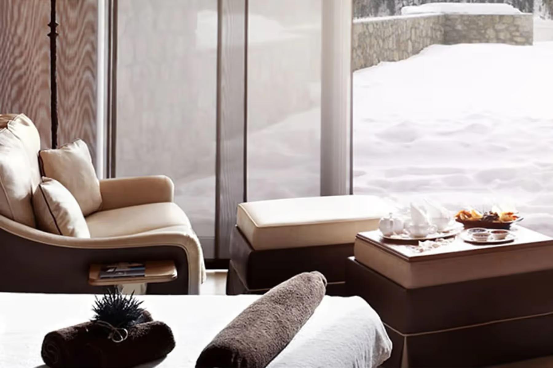 Badrutt’s Palace Hotel: spa lounge with upholstered seating, view of snow-covered mountains