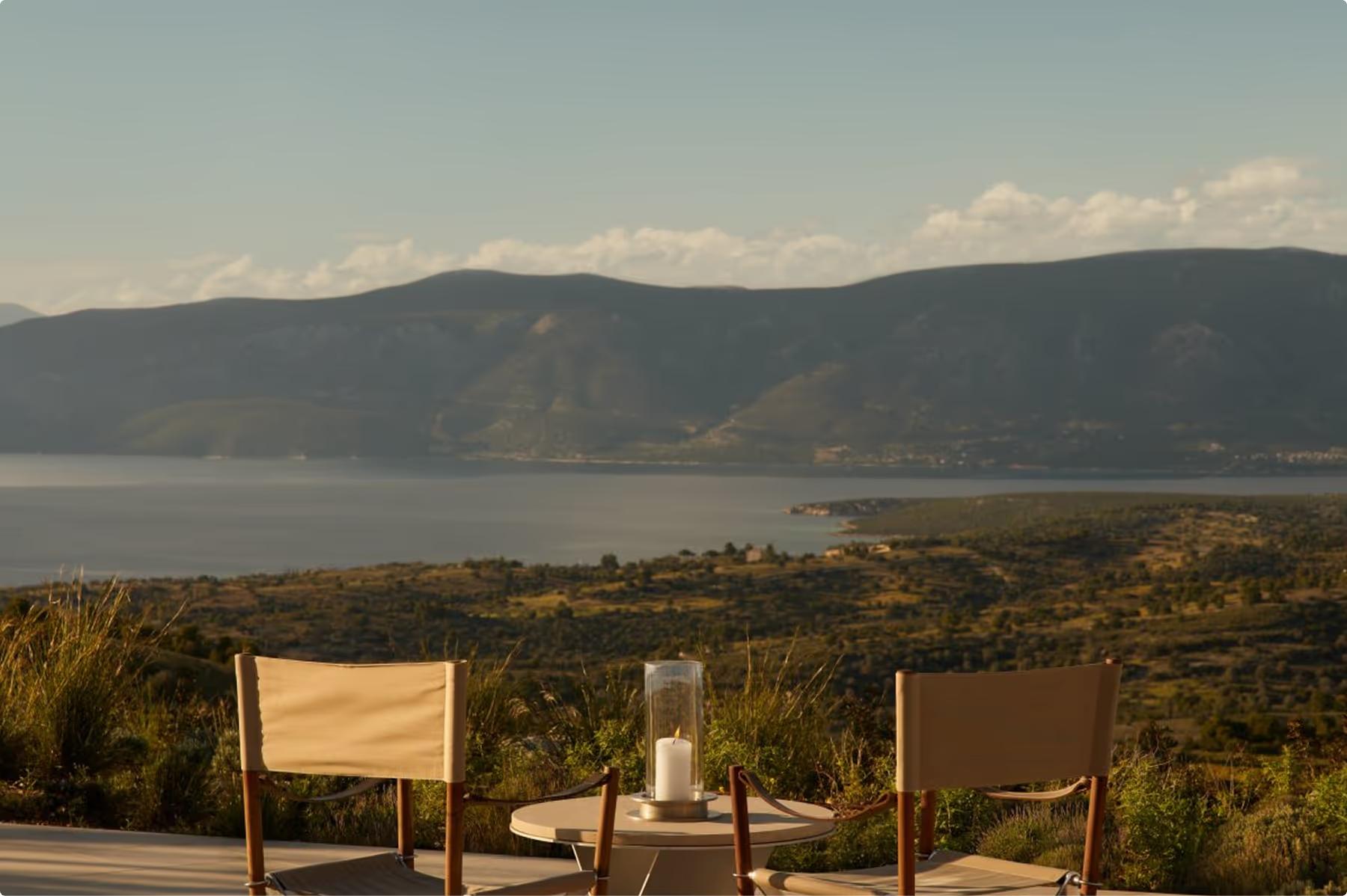 Amanzoe: alfresco dining at dusk with fire bowl and distant sea horizon
