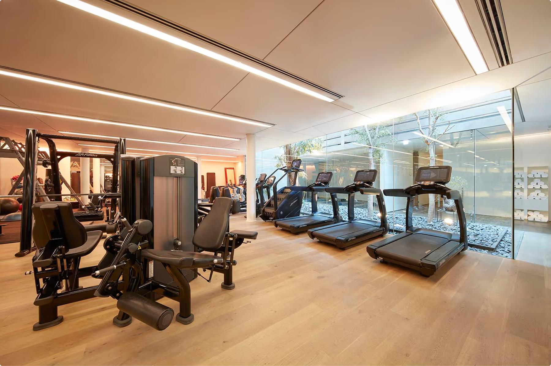 Mandarin Oriental Conservatorium, Amsterdam: fitness center with exercise equipment and floor-to-ceiling windows overlooking the city