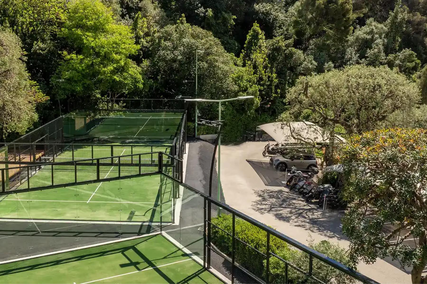 Hôtel Hermitage Monte-Carlo: outdoor tennis courts on hillside with green surfaces and perimeter fencing