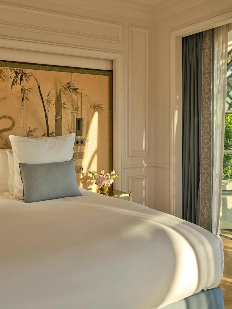 A bedroom at Château de La Messardière with a gilded bamboo screen above the bed