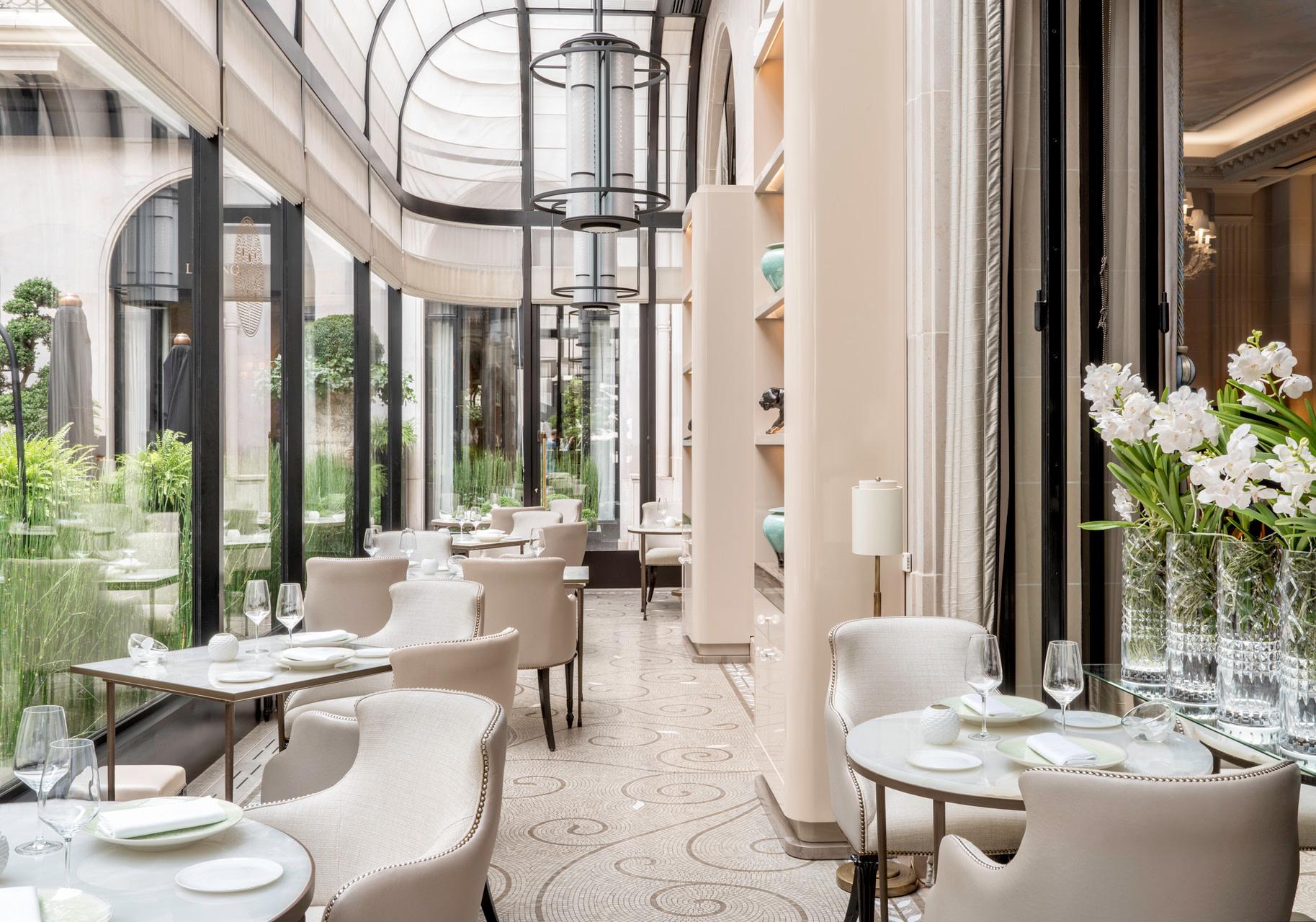 A dining room with tall arched ceilings, elegant table settings, and fresh florals