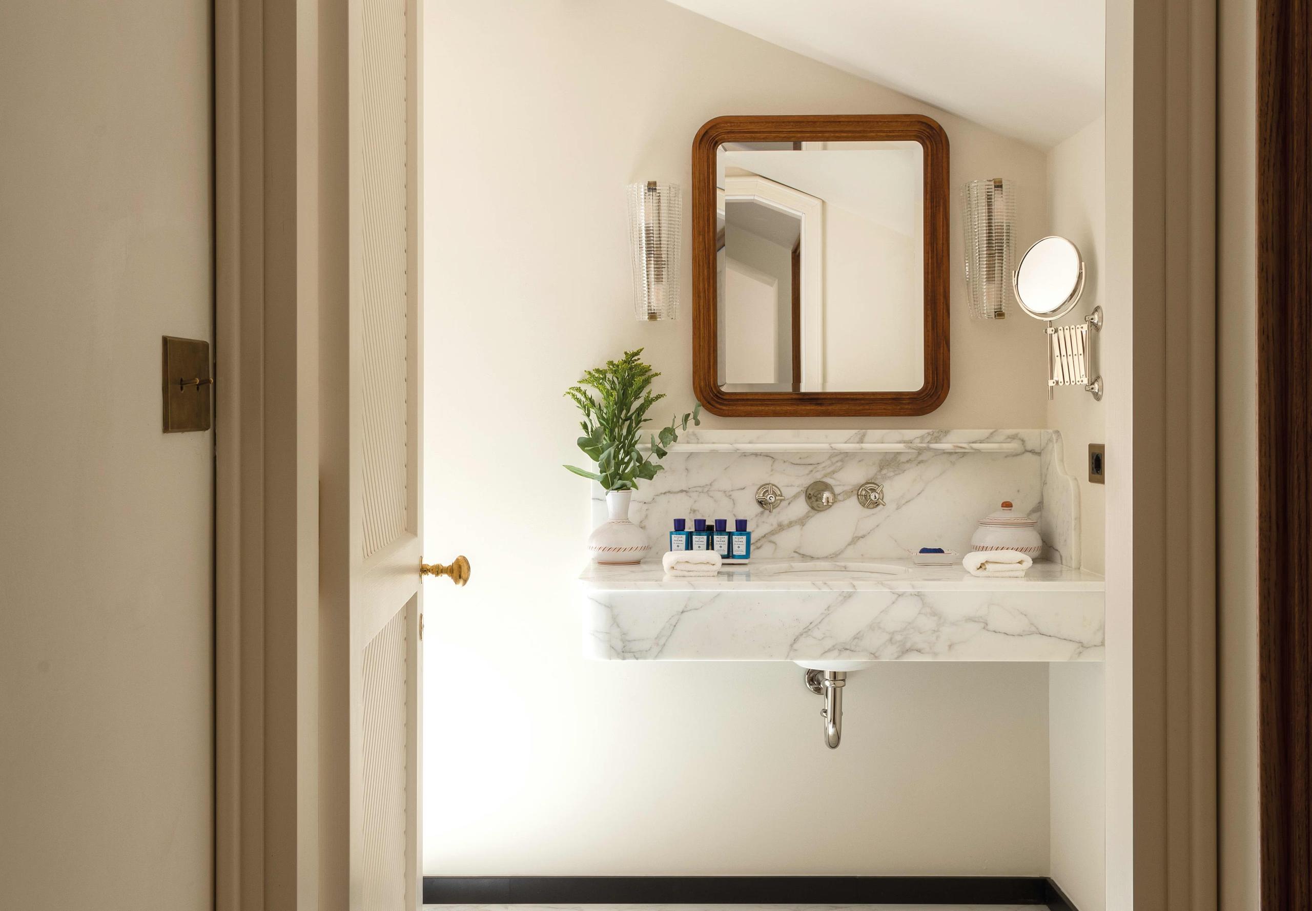 Bathroom with wooden-framed mirror and potted plant
