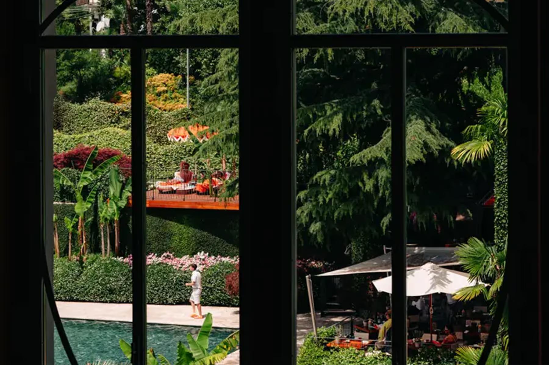 Garden view through arched windows showing flowering landscape