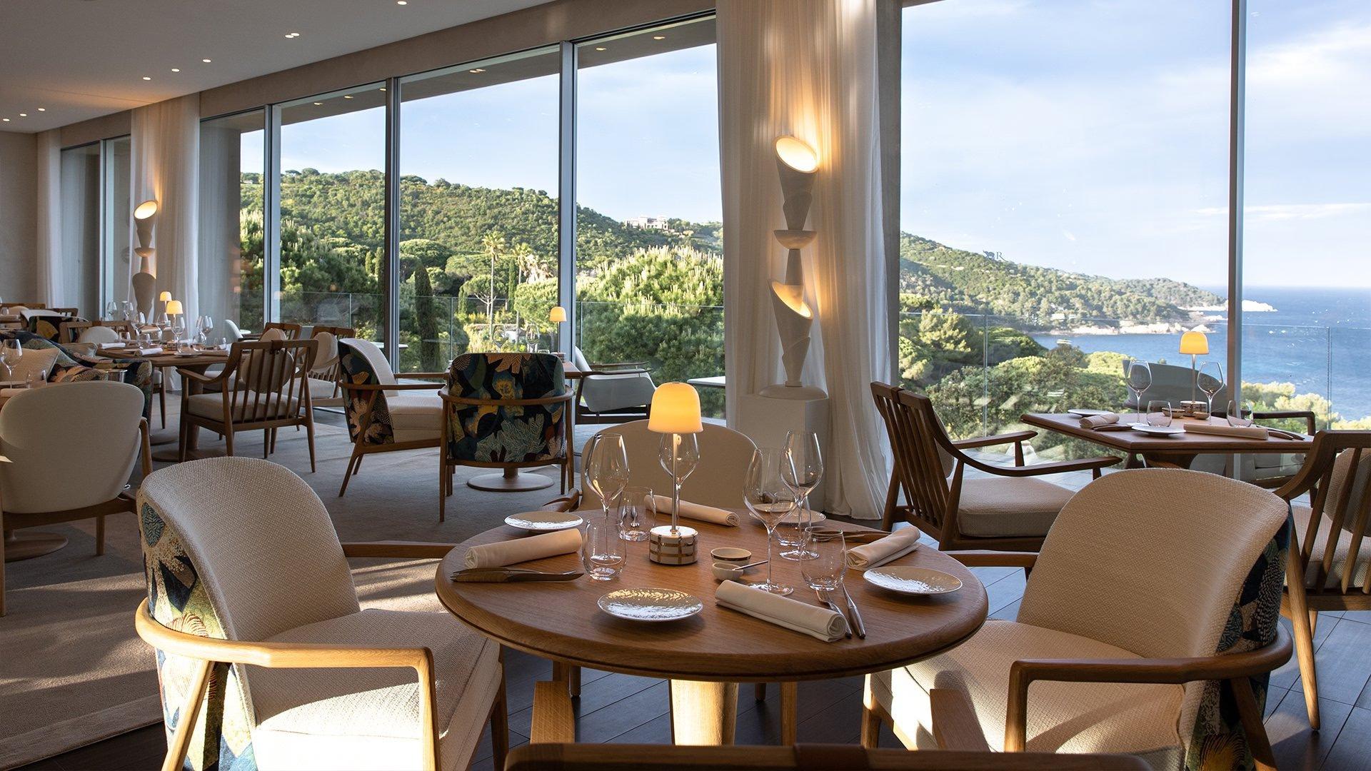 La Réserve Ramatuelle: restaurant with round wood table and floor-to-ceiling views