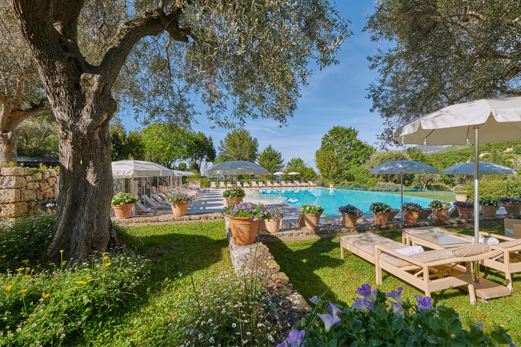 Château Saint Martin & Spa: garden cabana with pergola shade and lounge seating under cypress trees