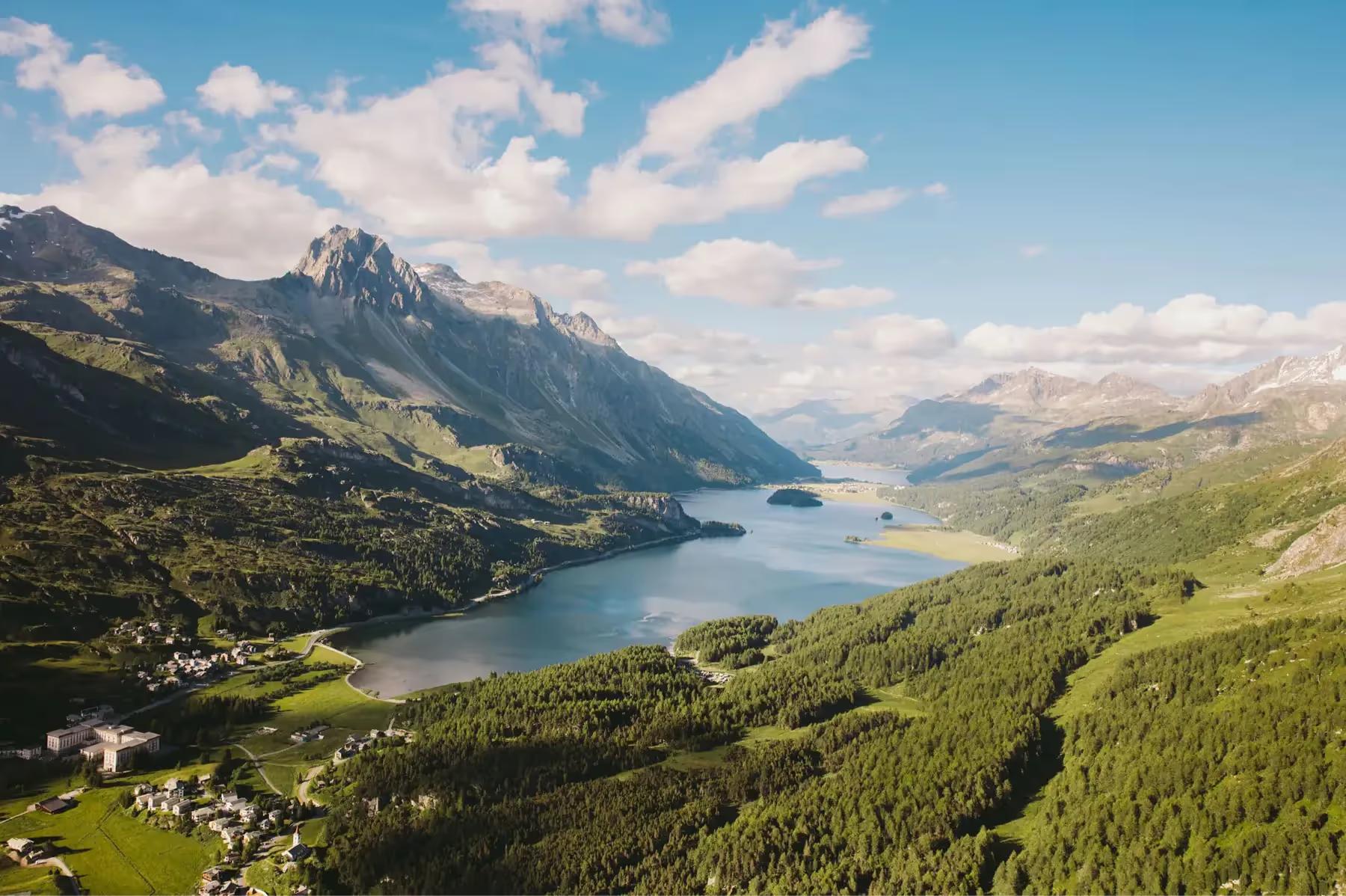 Kulm Hotel St. Moritz: an aerial view of the lake surrounded by forested valleys and snow-capped peaks