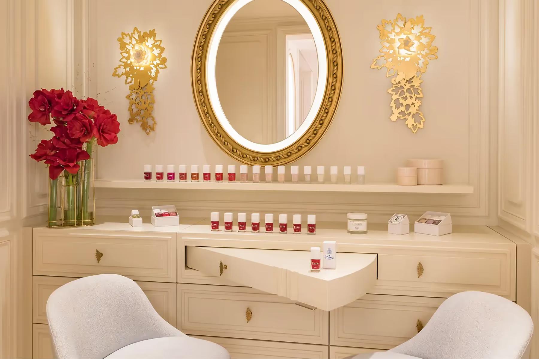 Ritz Paris: a spa treatment room with round mirror, cream furnishings, and pink floral accent