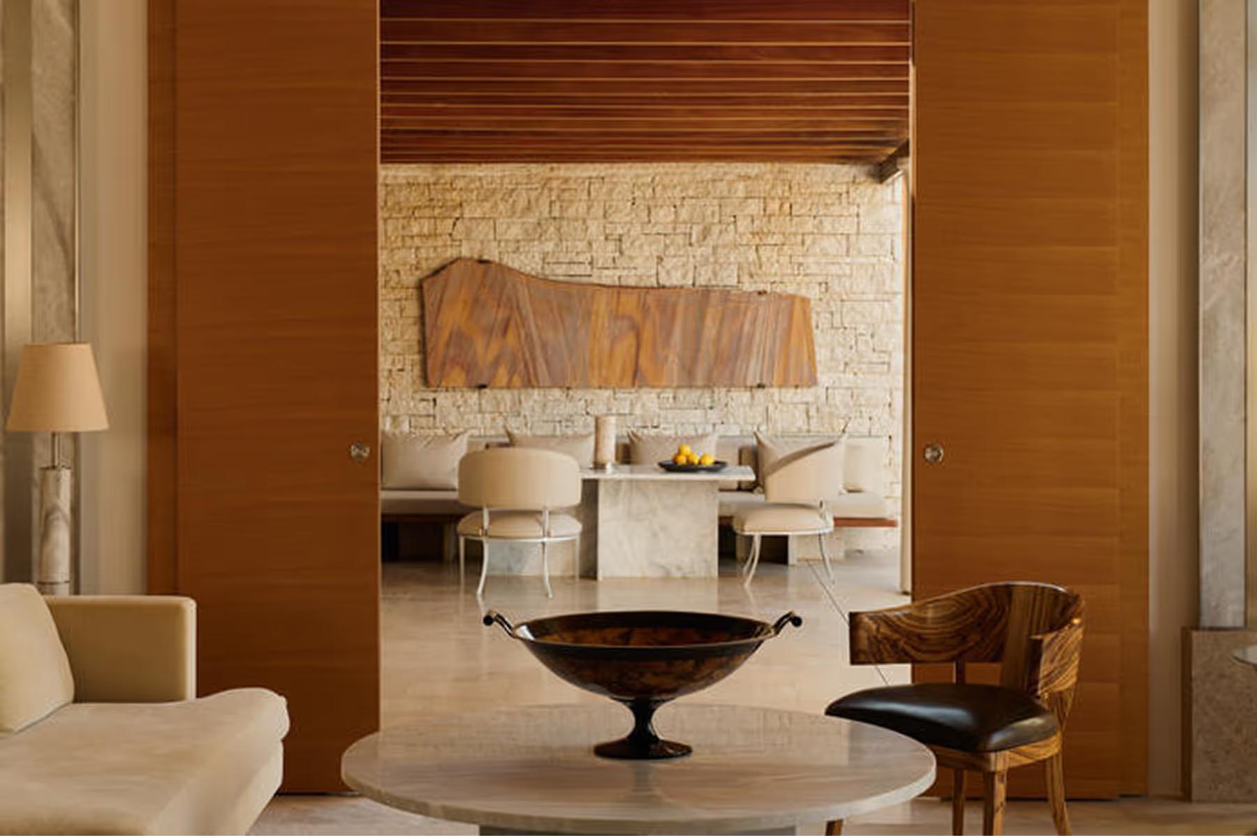 Living area with terracotta walls, dark furnishings and marble details