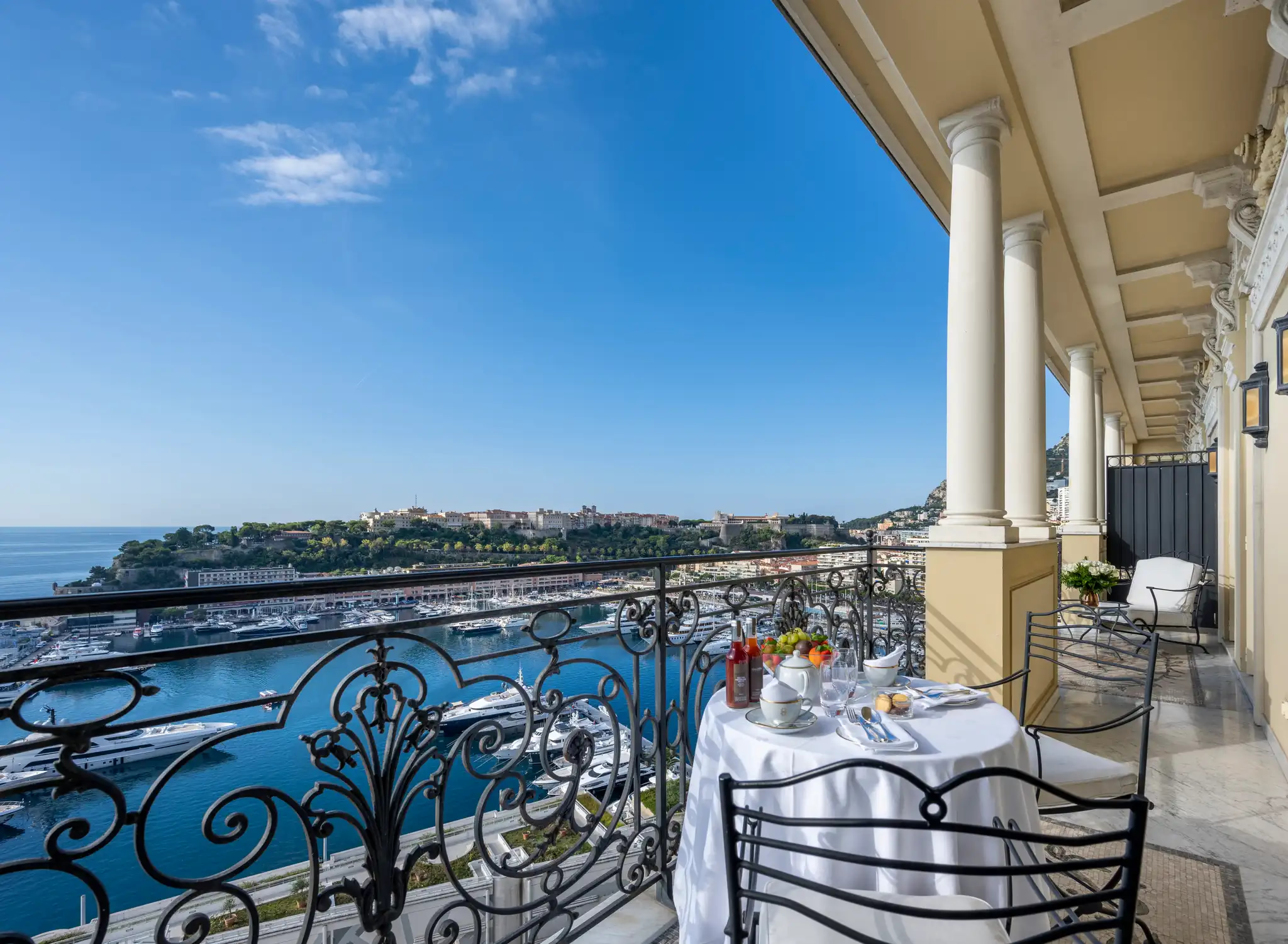 Hôtel Hermitage Monte-Carlo: wrought-iron terrace railing with sea and coastal buildings visible under blue sky
