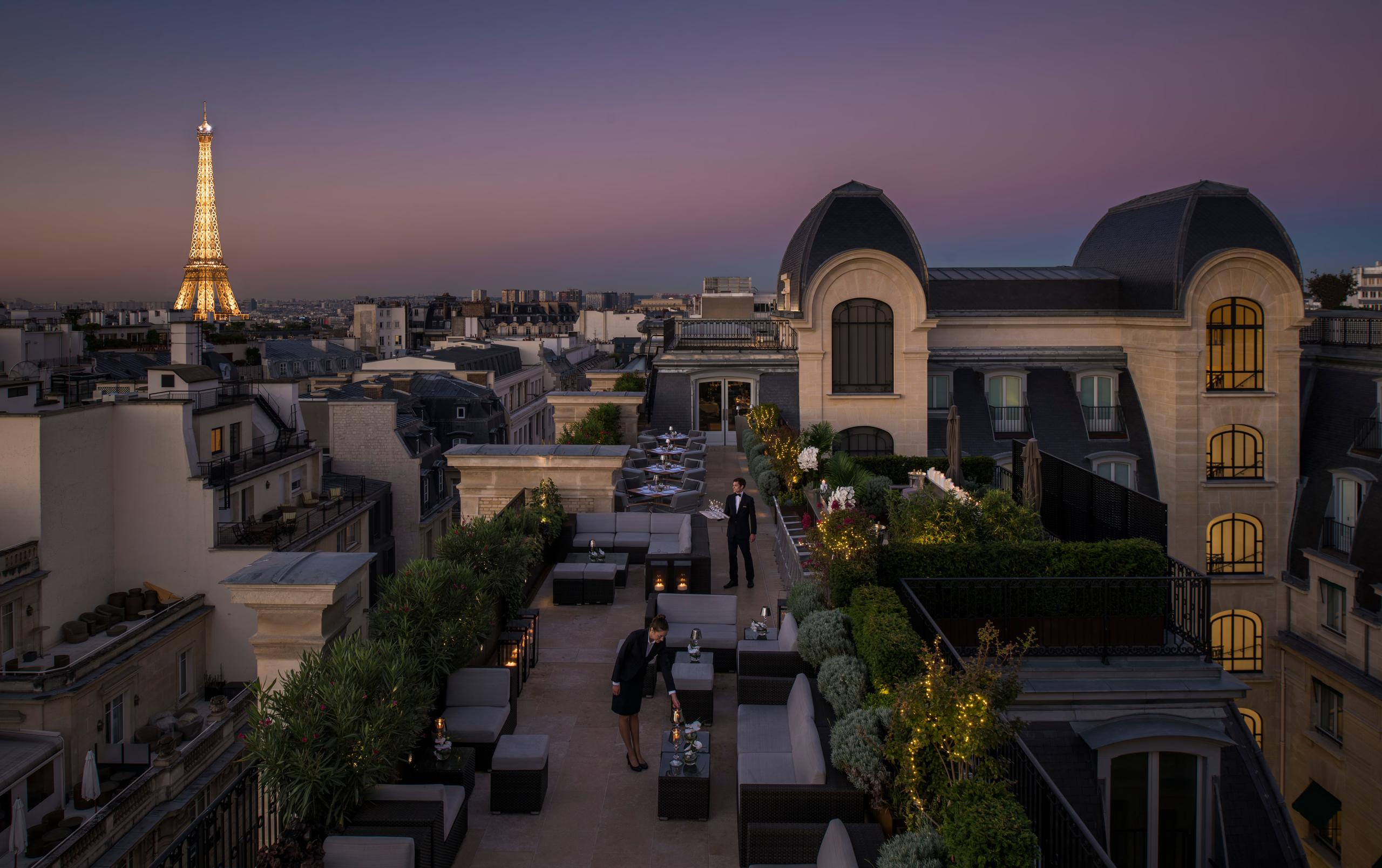 The Peninsula: building exterior at twilight with city views and the Eiffel Tower in the distance