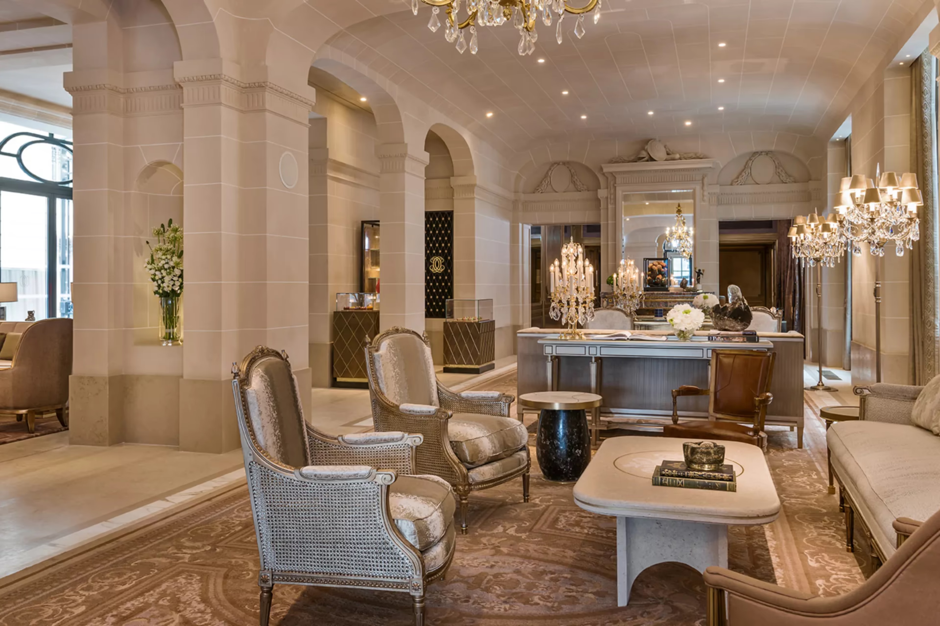 Grand lobby with chandelier, pale columns, and spacious classical architecture