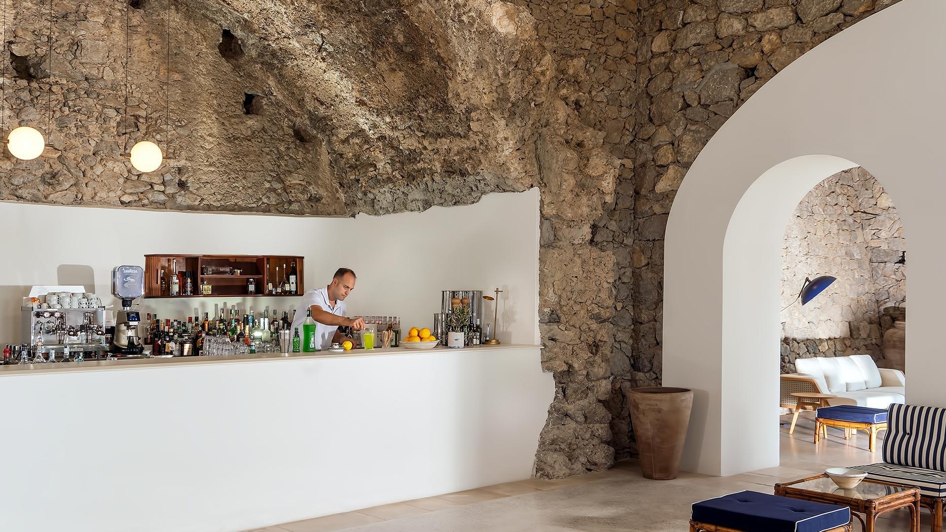 Bar counter in stone-walled space with exposed masonry and display shelving