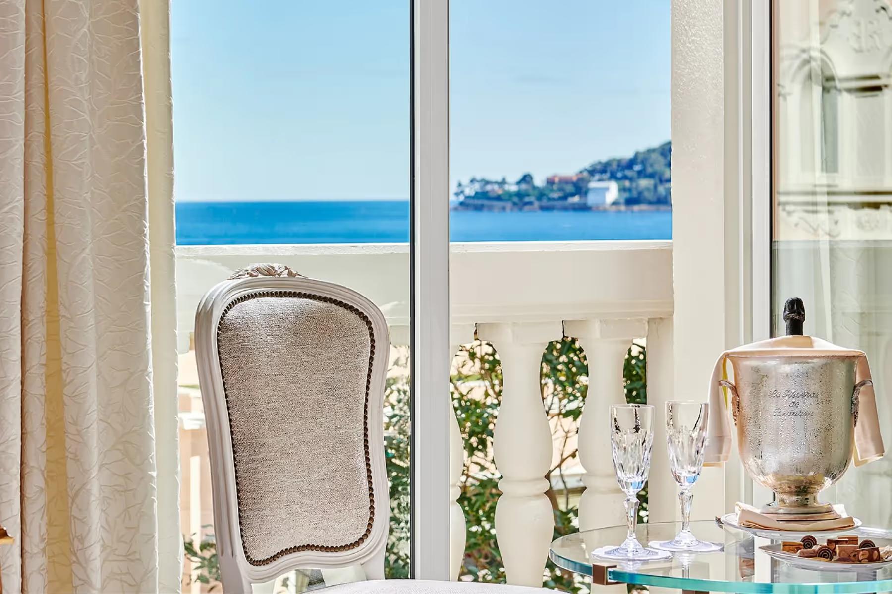 Window with mirror and potted plant overlooking the sea and coastline