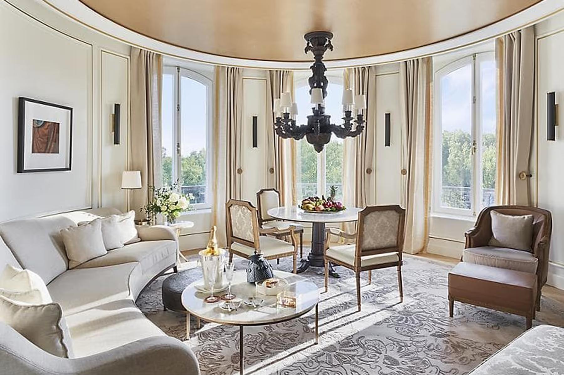 Curved parlor with black chandelier, upholstered seating, and inlaid marble floors