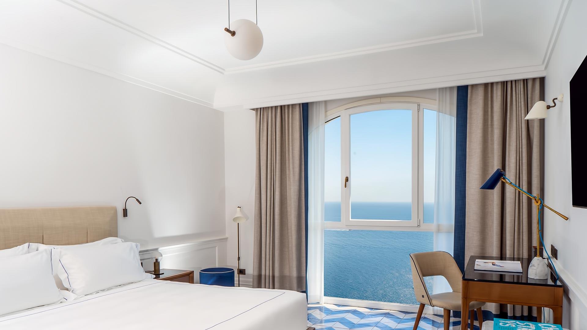 Borgo Santandrea: bright bedroom suite with full-width ocean views and minimalist furnishings