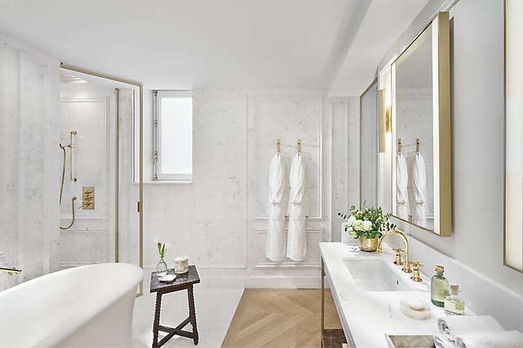 Mandarin Oriental Ritz, Madrid: modern bathroom with freestanding tub, white tiles, and brass fixtures