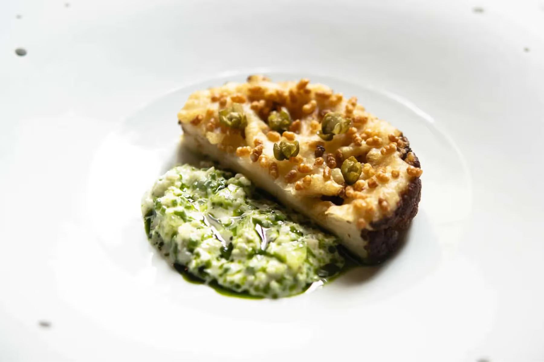 La Réserve Paris: a plated main course with herb sauce on white dinnerware