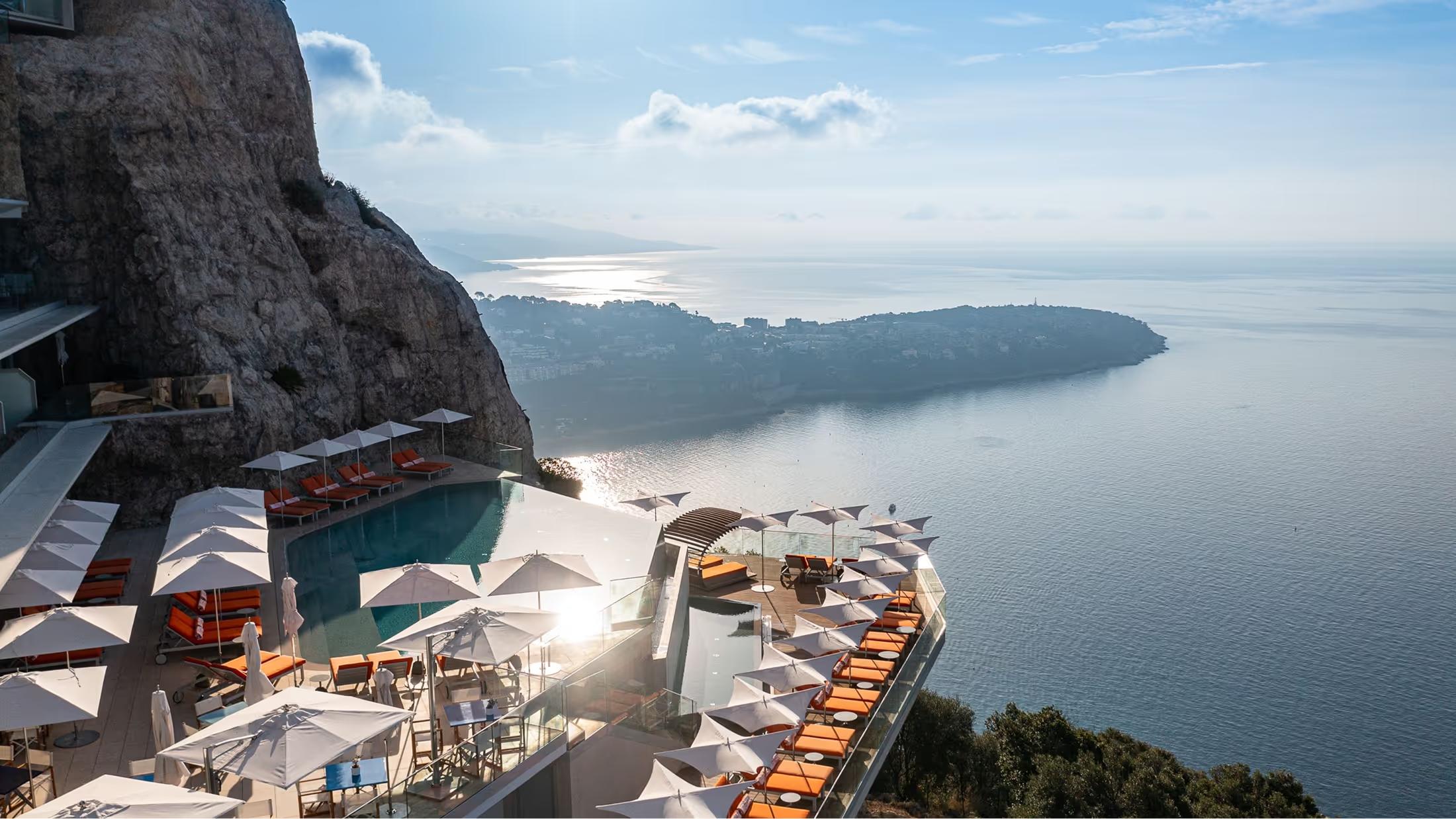 Clifftop hotel with sun lounges and sea view at dusk