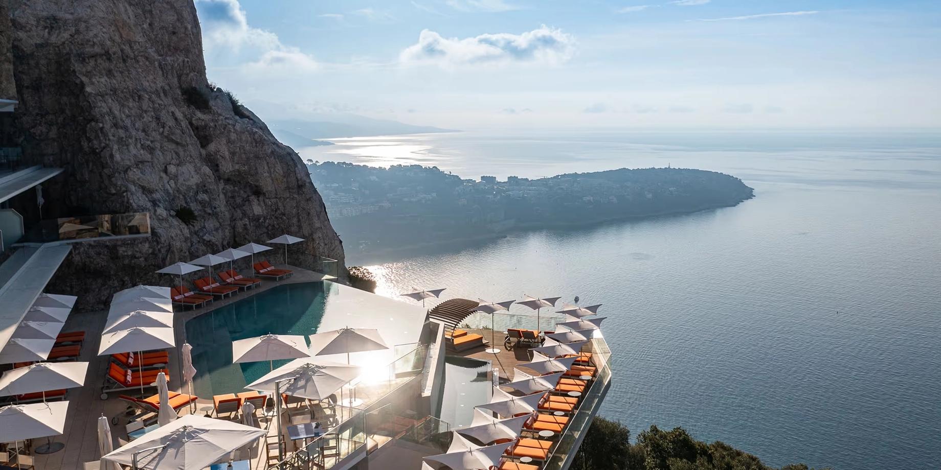 Clifftop hotel with sun lounges and sea view at dusk
