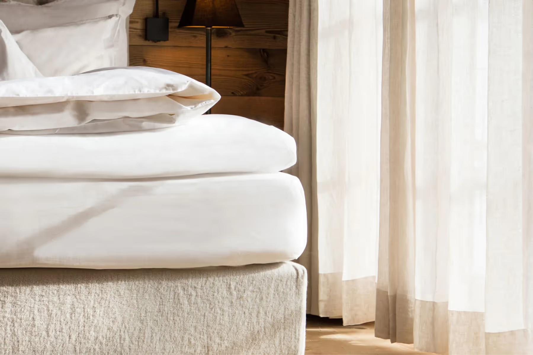 San Luis Retreat: close-up of white pillows and bedding on a wooden platform bed