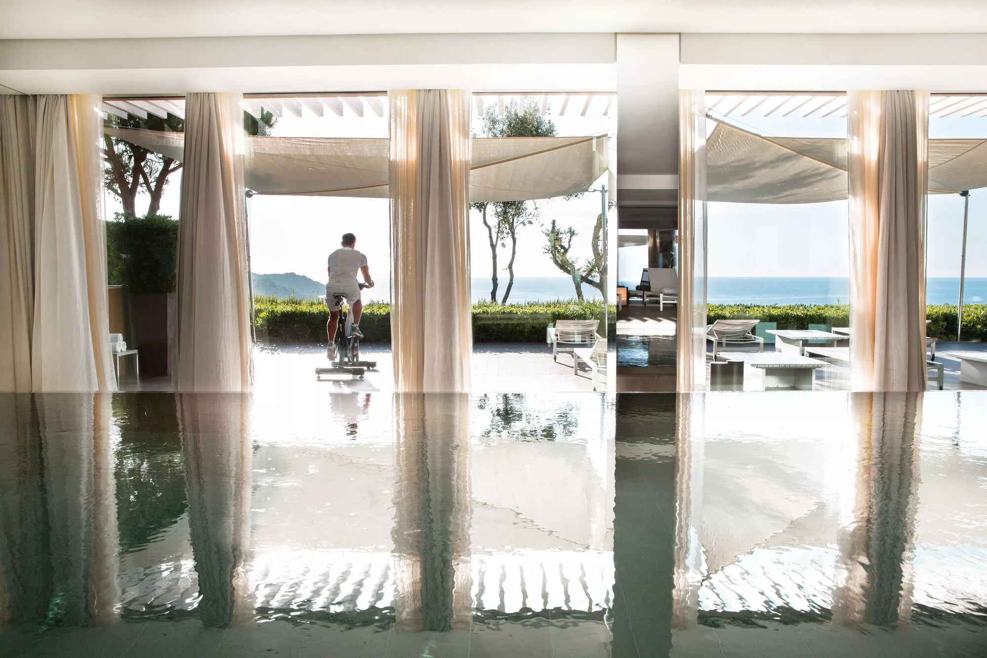 La Réserve Ramatuelle: light-filled spa hallway with white walls and sea views