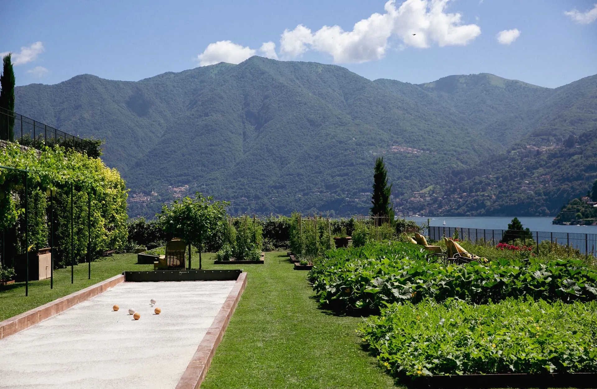 Passalacqua: manicured lawn with bocce court, cypress trees, and distant lake
