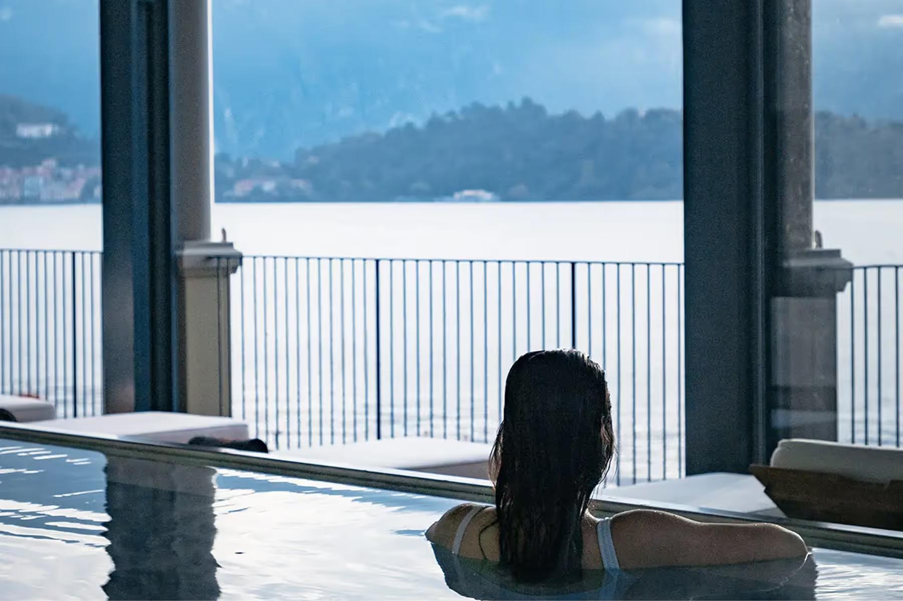 Grand Hotel Tremezzo: person soaking in thermal spa pool with mountain-lake panorama