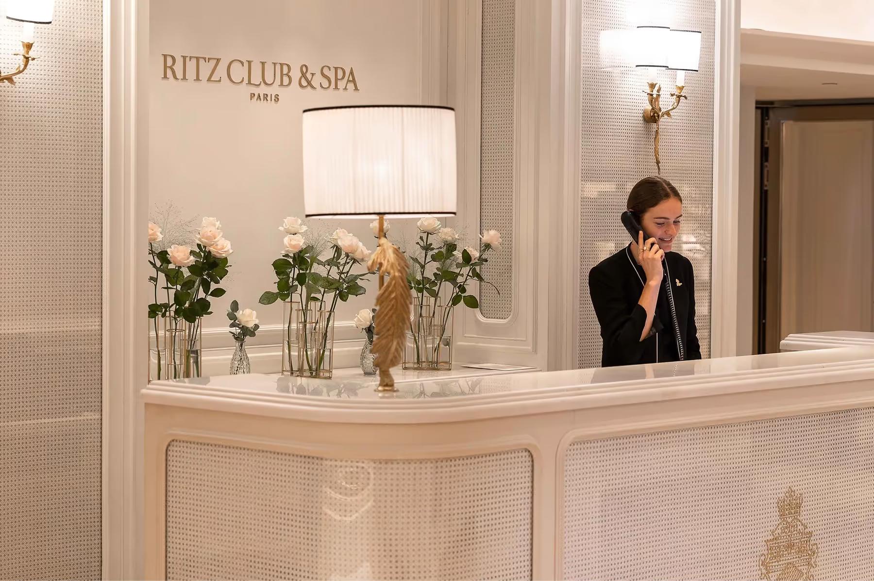 The Ritz Club & Spa reception desk with white marble and fresh floral arrangement