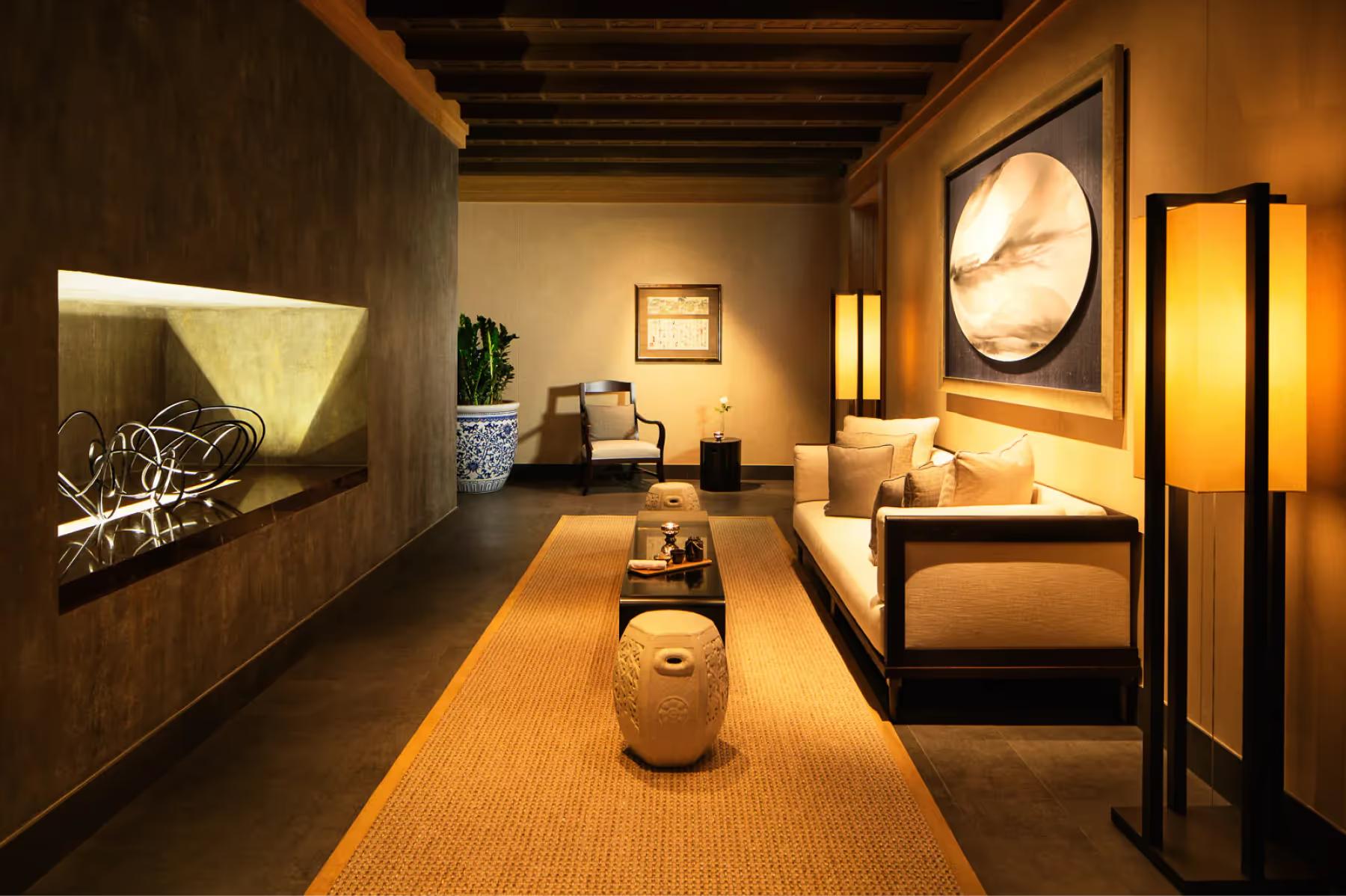 Spa corridor with warm wood tones, sconces, and treatment rooms in ambient lighting
