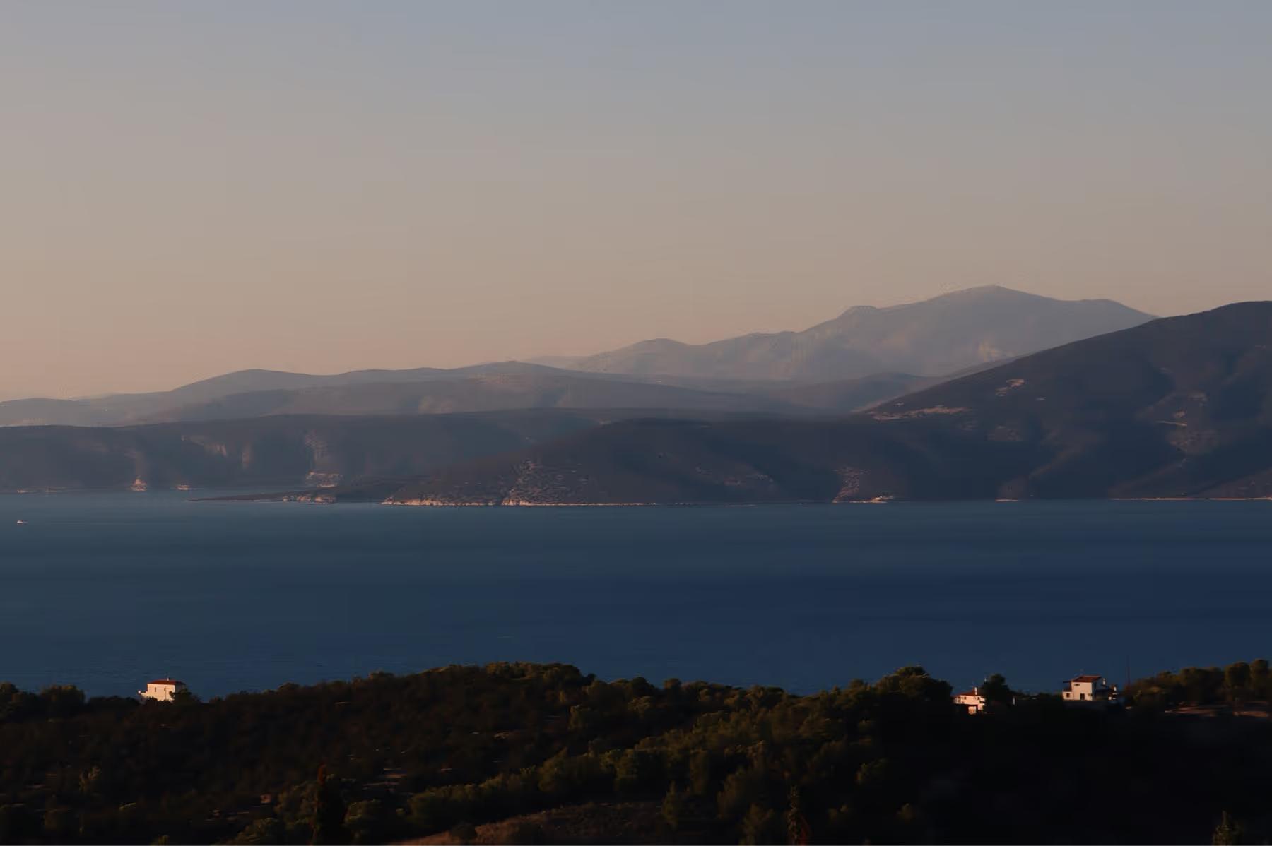 Amanzoe: twilight view of the water with distant resort lights