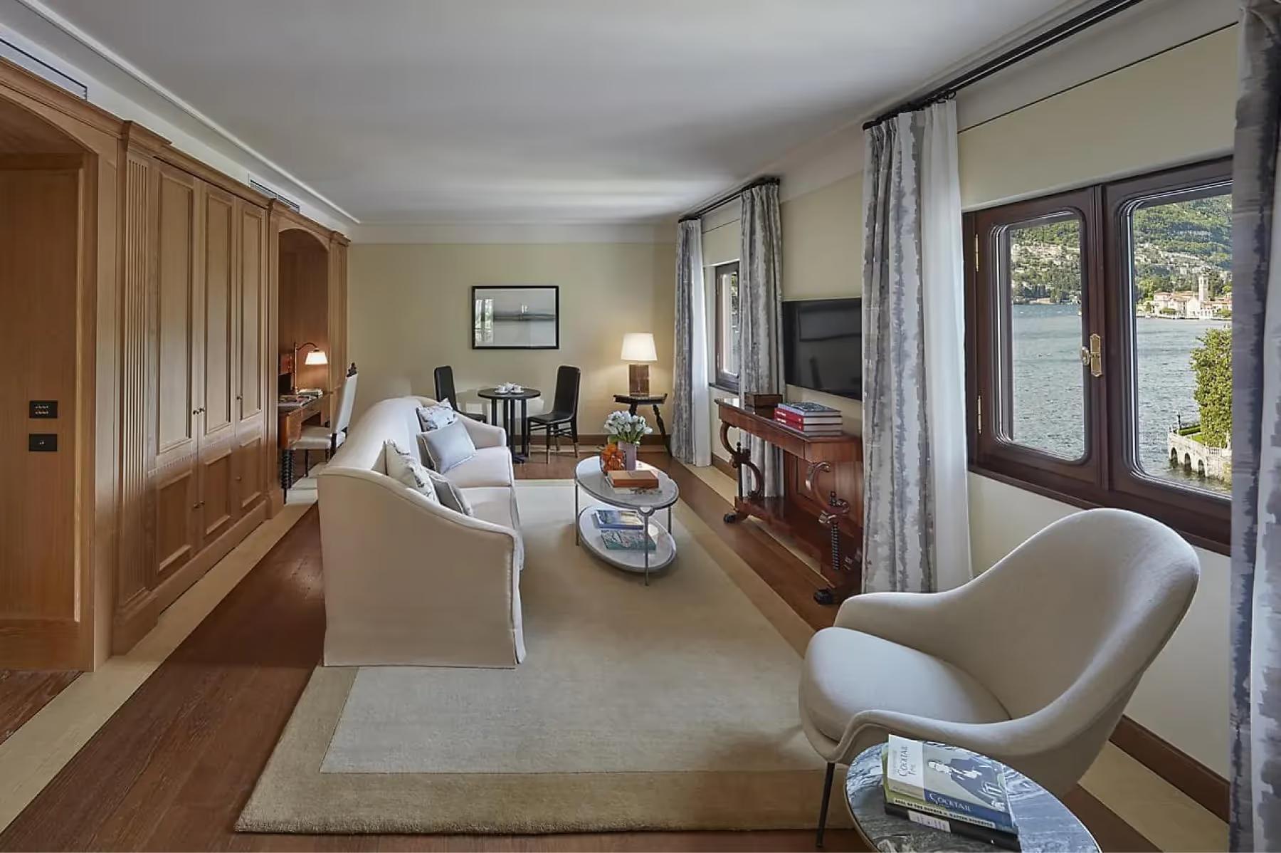 Mandarin Oriental, Lake Como: suite with light furnishings, multiple seating zones, and views across lake to mountains