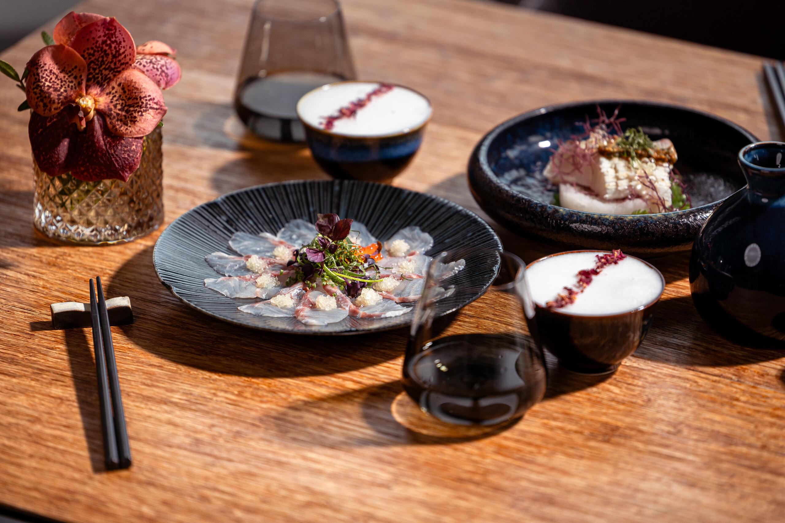 Park Hotel Vitznau: plated cuisine on dark ceramic dishes with wine and floral arrangement