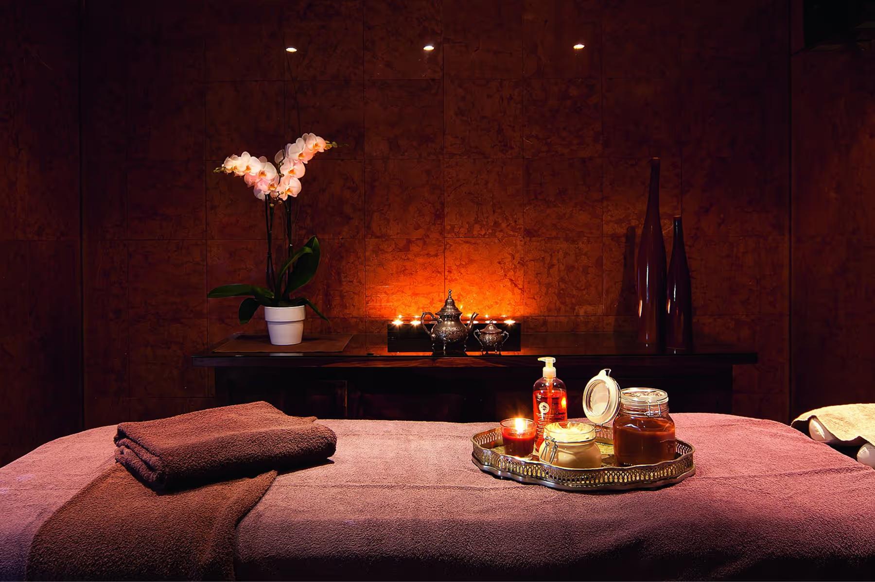 Althoff Villa Belrose: spa interior with burgundy tones, heated massage table, and ambient lighting