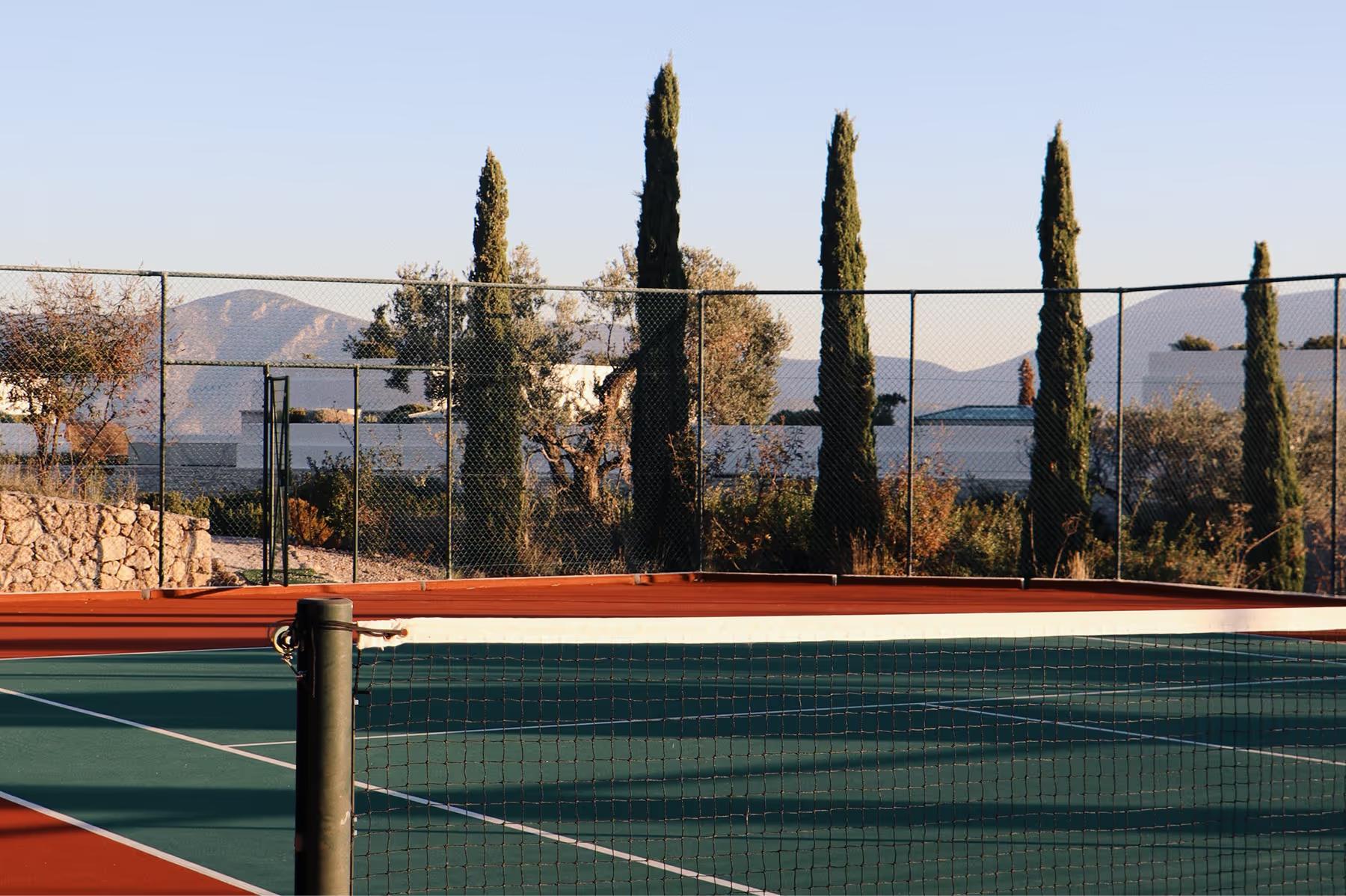 Amanzoe: tennis court overlooking the Aegean with cypress trees