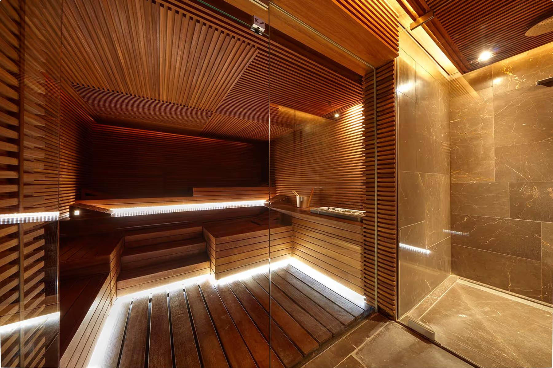 Mandarin Oriental Conservatorium, Amsterdam: sauna room with wooden slat interior, bench seating, and frosted glass steam room entrance