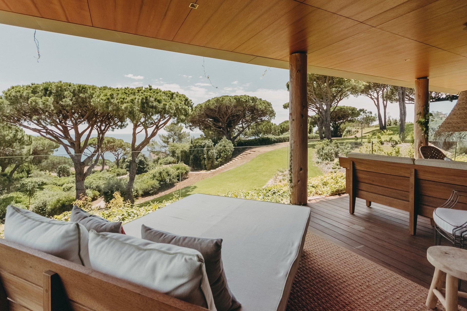 Lily of the Valley: shaded terrace with wooden furniture and Mediterranean landscape in distance