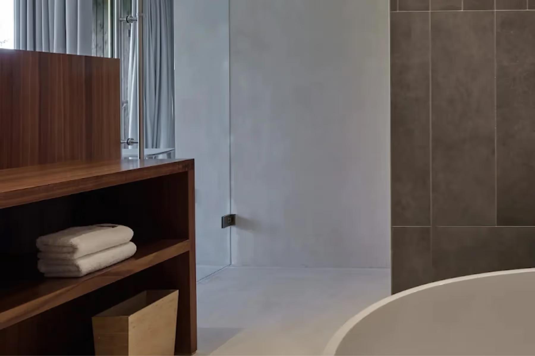 Bathroom with wood vanity, white sink, and frosted glass partition wall