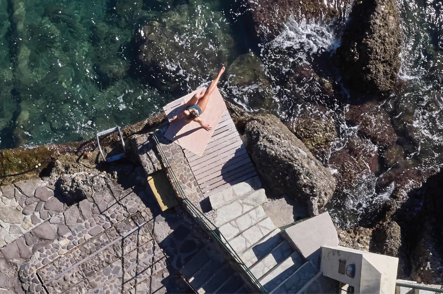 Splendido: a wooden platform and stairs descending to the sea from a rocky coastal point