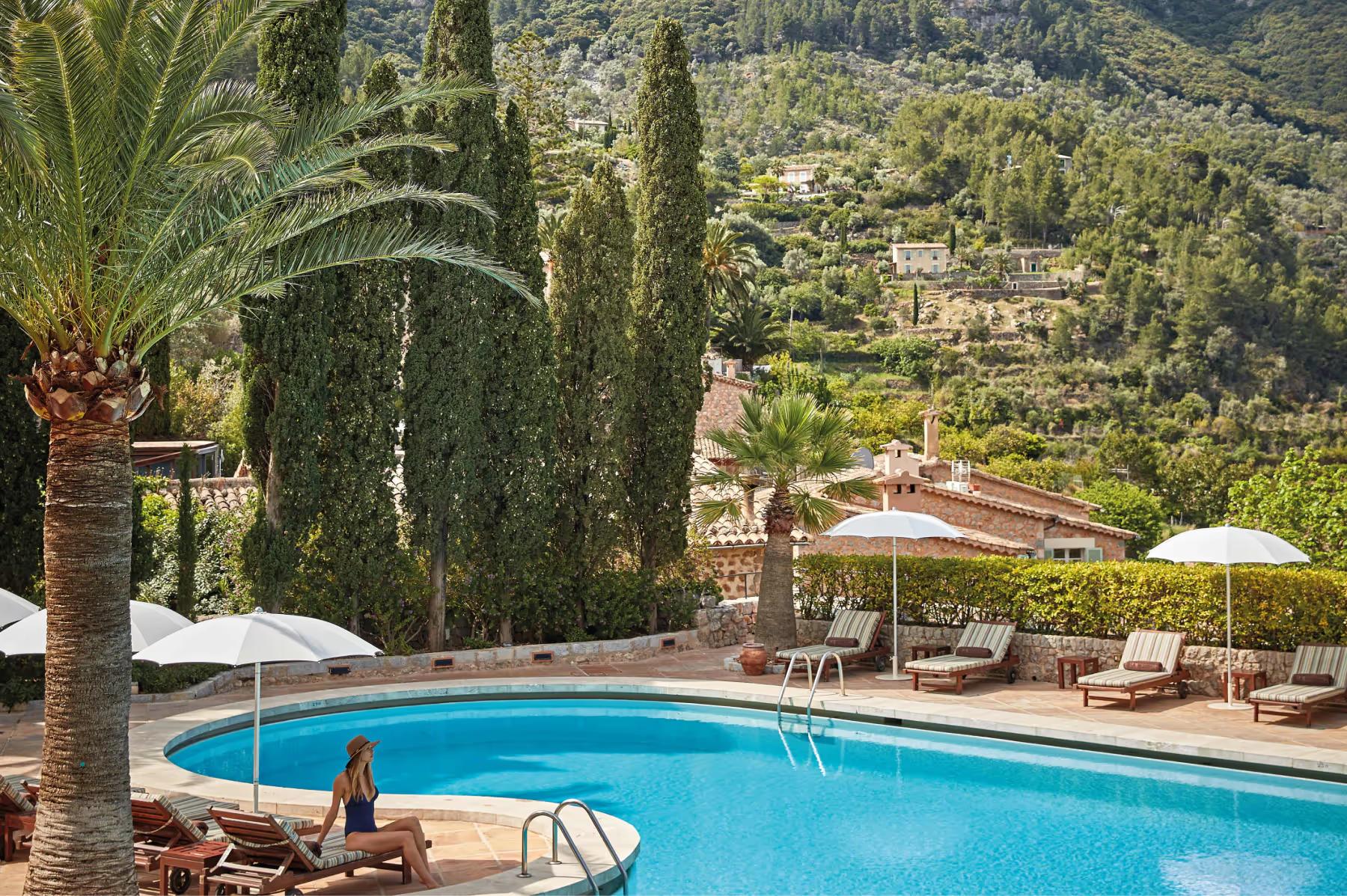 La Residencia: resort pool with lounge chairs and umbrellas overlooking Mediterranean countryside
