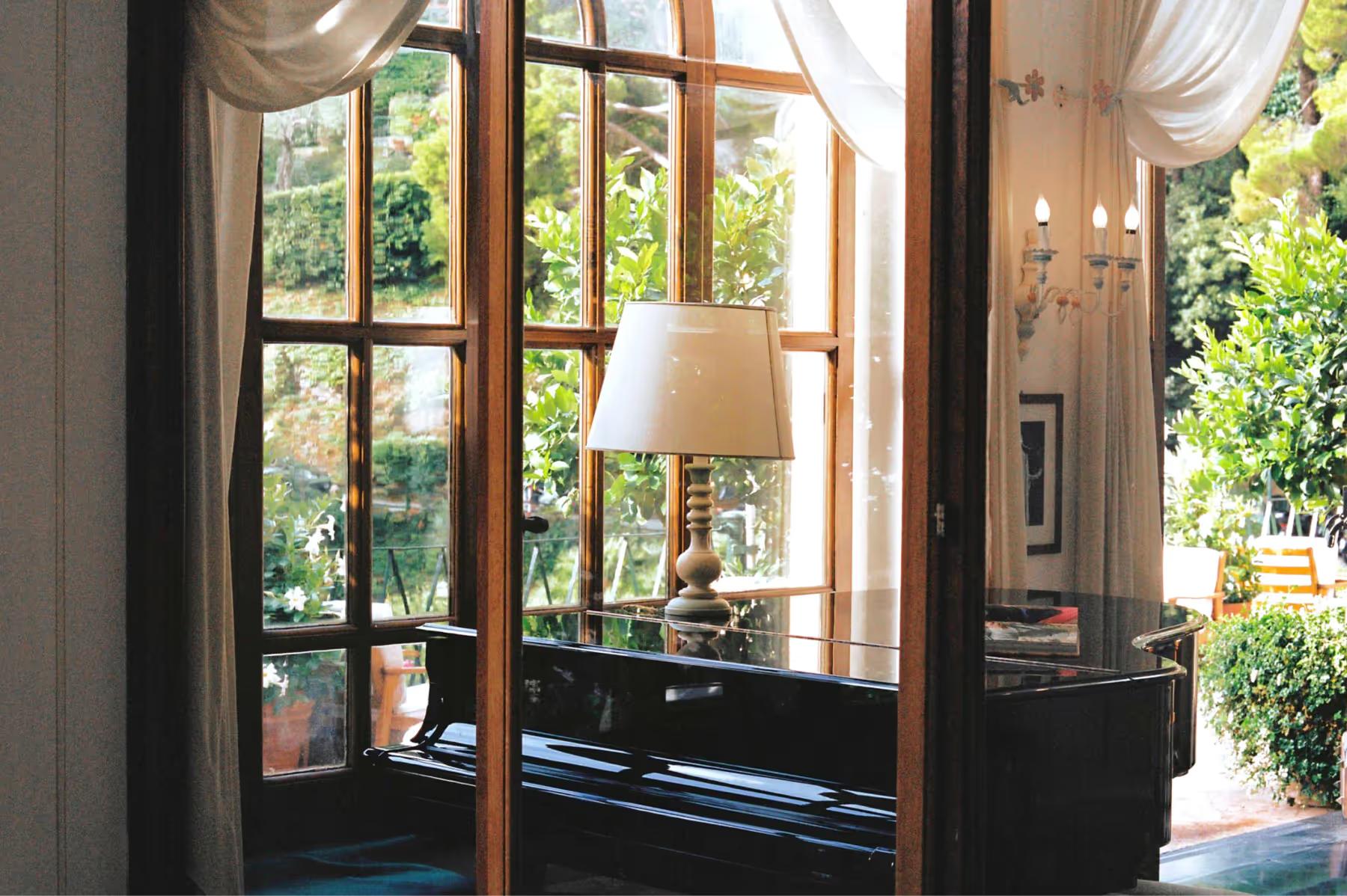 Splendido: dark wooden doors with brass handles and arched transom opening onto light interior