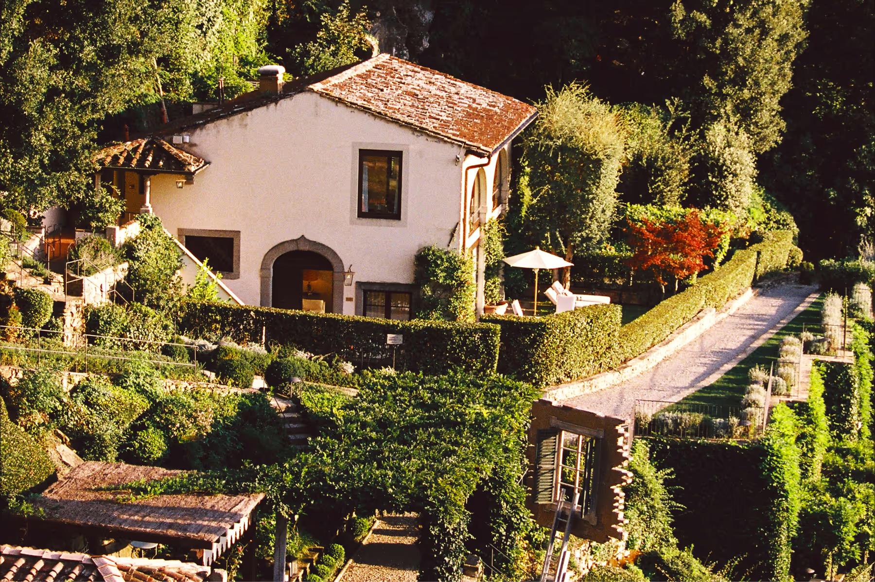 Villa San Michele: aerial view of a villa building with terracotta roof, arched windows, and surrounded by manicured gardens