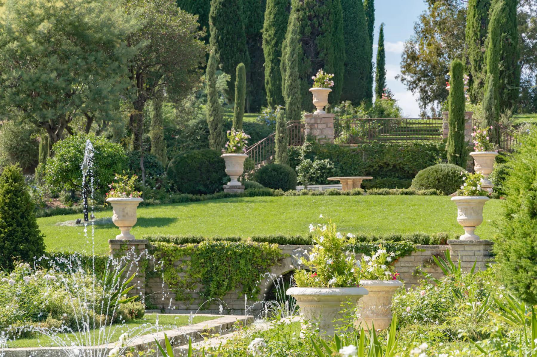 Le Château de La Croix des Gardes: terracotta urns and statuary on tiered garden beds with cypress groves and Mediterranean views