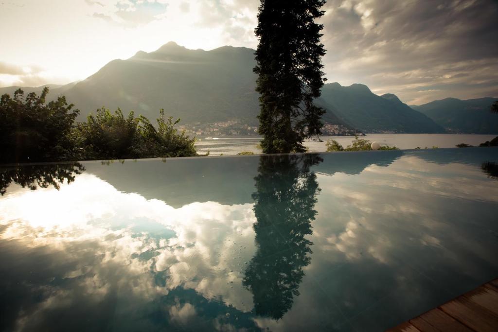 Villa Làrio: infinity pool reflecting mountains and clouds at dawn